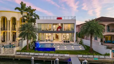 a house with a swimming pool in front of a house at Miami Modern Heated Pool and Dock in Sunny Isles Beach