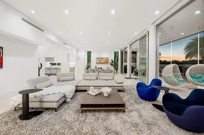 a living room with a white couch and blue chairs at Miami Modern Heated Pool and Dock in Sunny Isles Beach