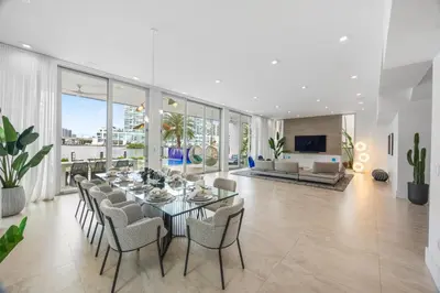 a dining room and living room with a table and chairs at Miami Modern Heated Pool and Dock in Sunny Isles Beach