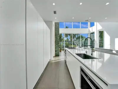 a kitchen with white counters and a large window at Modern waterfront property in Fort Lauderdale