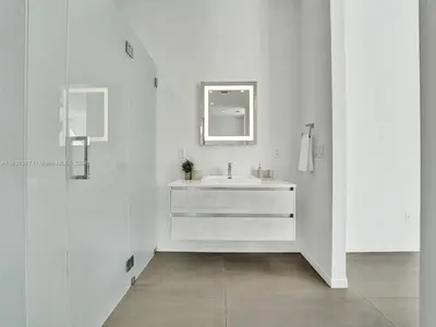 a white bathroom with a sink and a mirror at Modern waterfront property in Fort Lauderdale