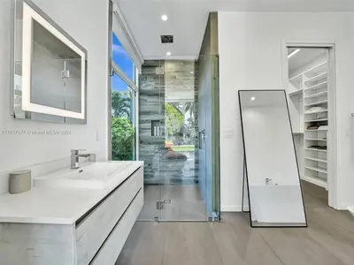 a white bathroom with a sink and a mirror at Modern waterfront property in Fort Lauderdale