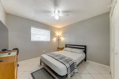 a bedroom with a bed and a ceiling fan at Fenced-In Yard Home 3 Mi to Hard Rock Stadium! in Miramar