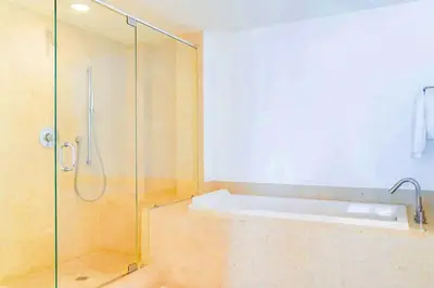 a bathroom with a glass shower with a tub at Luxury Living in Brickell - Stunning City Views in Miami