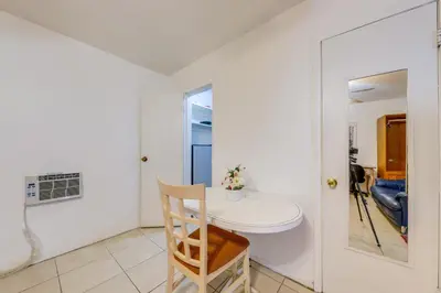 a white room with a table and a chair at 8 Mi to Beach! Miramar Guest Suite with Pool Access in Miramar