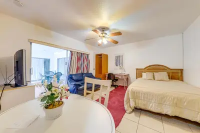 a bedroom with a bed and a table and a tv at 8 Mi to Beach! Miramar Guest Suite with Pool Access in Miramar