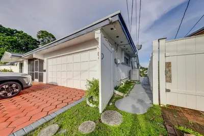 a house with a white garage and a driveway at 5 Mi to Hollywood Blvd! Miramar Apt with Shared Pool in Miramar