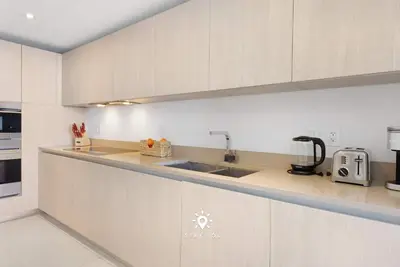 a kitchen with white cabinets and a sink at Beautiful 1BR Apartment with Ocean View Balcony in Hollywood