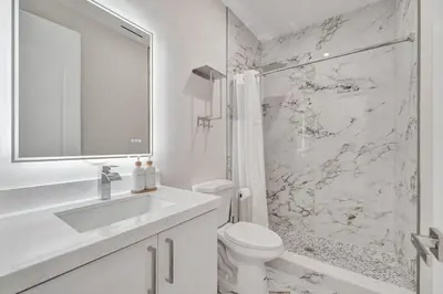 a white bathroom with a toilet and a sink at New 4BR Upscale Family Haven in Fort Lauderdale