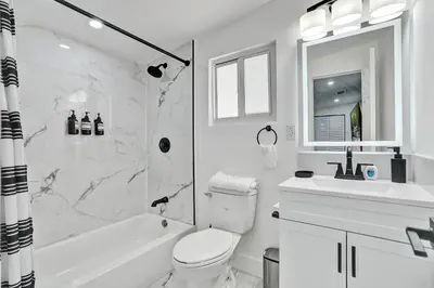 a white bathroom with a toilet and a sink at Miami Heart Retreat, Stylish & Central With Games in Miami