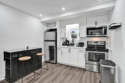 a kitchen with white cabinets and stainless steel appliances at Heart of Miami Oasis, Modern, Steps from It All in Miami