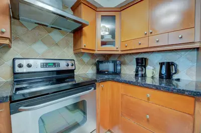 a kitchen with wooden cabinets and a stove top oven at Casablanca Residences Miami Beach in Miami Beach