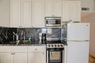 a kitchen with white cabinets and a white refrigerator at Casablanca Residences Miami Beach in Miami Beach