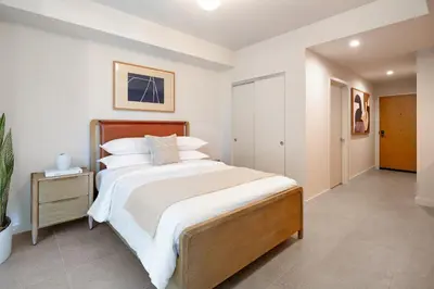 a bedroom with a large bed with white sheets at The Crosby Miami World Center in Miami