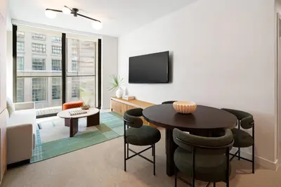 a living room with a table and chairs and a tv at The Crosby Miami World Center in Miami