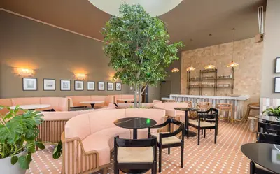 a restaurant with tables and chairs and plants at The Crosby Miami World Center in Miami