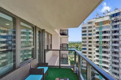 an apartment balcony with views of a building at Oceanfront Escape with Resort Amenities Gym Pools and Sauna 1408 in Miami Beach