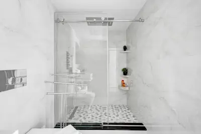 a white bathroom with a shower and a toilet at Oceanfront Escape with Resort Amenities Gym Pools and Sauna 1408 in Miami Beach