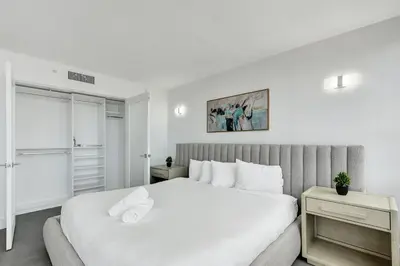 a white bedroom with a large bed and a window at Oceanfront Luxury 3BR 3BA Condo with Resort Pools Gym and Sauna 902 in Miami Beach