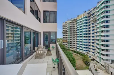 an apartment balcony with a view of two tall buildings at Oceanfront Luxury 3BR 3BA Condo with Resort Pools Gym and Sauna 902 in Miami Beach