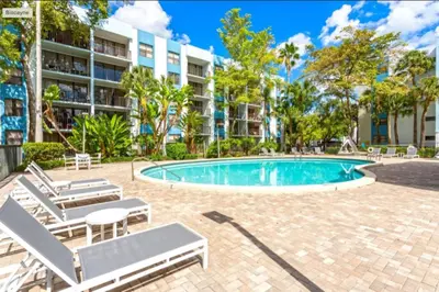 a swimming pool with lounge chairs and a building at Urban Escape 2 Bed Unit In Miami near Whole Foods in North Miami
