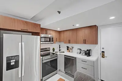 a kitchen with stainless steel appliances and wooden cabinets at Modern 4BR with Ocean Views Pools and Direct Beach Access in Miami Beach