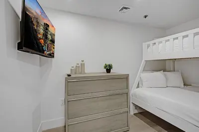 a bedroom with a bed and a tv on a wall at Modern 4BR with Ocean Views Pools and Direct Beach Access in Miami Beach