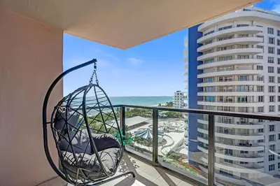 a swing on a balcony with a view of a building at Miami Beach Paradise 4BR Stylish condo with Resort Perks 1007 in Miami Beach