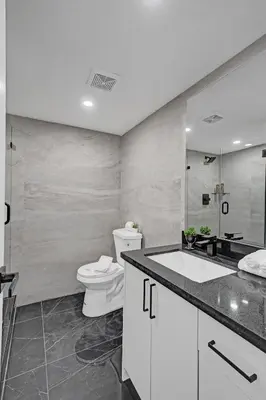 a white bathroom with a toilet and a sink at Miami Beach Paradise 4BR Stylish condo with Resort Perks 1007 in Miami Beach