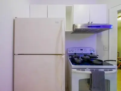 a white kitchen with a stove and a refrigerator at Stylish Miami retreat-Edgewater in Miami