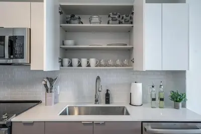 a kitchen with a sink and white cabinets at Event-Ready 2BR 2BA Near Stadium & Beach includes Parking and Washer and Dryer in Hallandale Beach