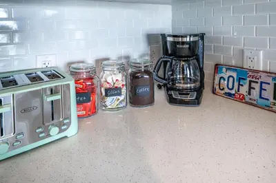 a kitchen counter with jars of coffee and a toaster at Event-Ready 2BR 2BA Near Stadium & Beach includes Parking and Washer and Dryer in Hallandale Beach