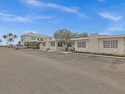 an empty parking lot in front of a house at Dania Beach Getaway | 2 Studios for 6 Guests in Dania Beach