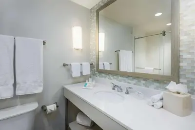 a white bathroom with a sink and a mirror at Hilton Garden Inn Miami Dolphin Mall in Miami