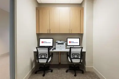 an office with two desks with two chairs and a printer at Hilton Garden Inn Miami Dolphin Mall in Miami