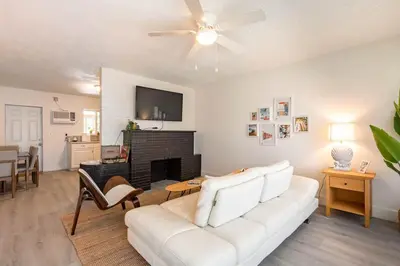 a living room with a white couch and a fireplace at 2BD 2BA Bungalow 5 min Dania Beach 15 min Hard Rock Stadium in Dania Beach
