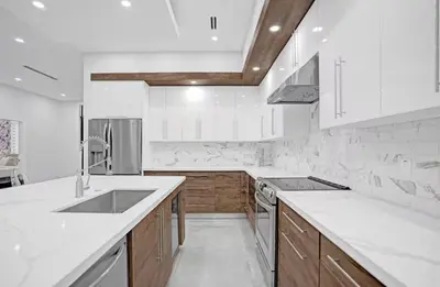 a kitchen with white counter tops and wooden cabinets at New Construction Villa HotTub Heated Pool Gameroom in Fort Lauderdale