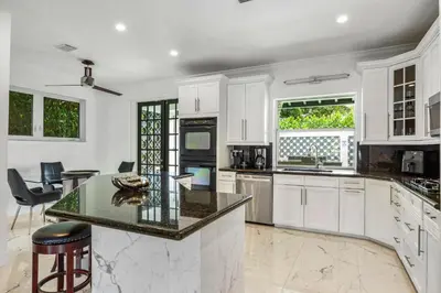 a kitchen with white cabinets and a counter top at Villa Asher - Waterfront with dock in Miami