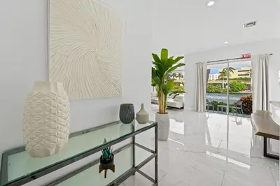 a living room with white walls and a glass table at Villa Harrison . in Hollywood