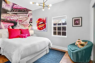 a bedroom with a large bed and a chair at Luxe 5BR 4BA I Heated Pool 10 Min to Beach I BBQ in Fort Lauderdale