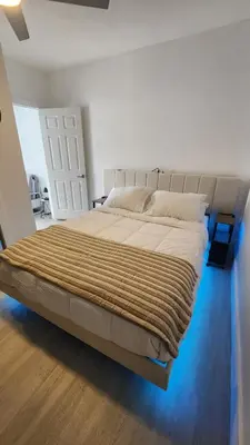 a bedroom with a large bed with white sheets at Blue Loft305 in Hialeah