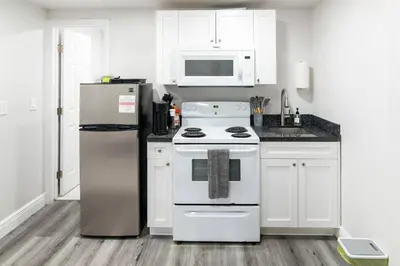 a kitchen with a stove and a refrigerator at Miami Shores Stay | Stylish Apt Minutes to Ocean in North Miami