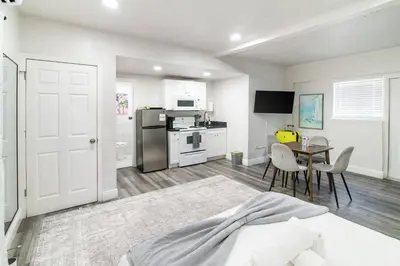 a white room with a kitchen and a table at Miami Shores Stay | Stylish Apt Minutes to Ocean in North Miami