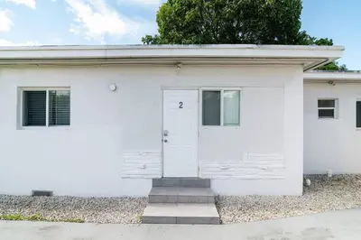 a white house with a white door at Miami Shores Stay | Stylish Apt Minutes to Ocean in North Miami