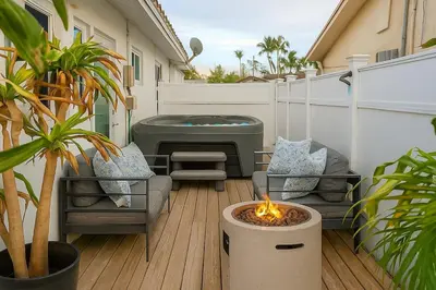 a patio with a hot tub and chairs and a fire pit at Steps from Airport Hot Tub Bbq Boat Slip in Dania Beach