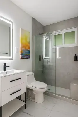 a white bathroom with a toilet and a shower at Waterfront HotTub Steps from the Airport Boat Slip in Dania Beach