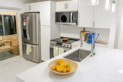 a kitchen with a bowl of oranges on a counter at Waterfront HotTub Steps from the Airport Boat Slip in Dania Beach