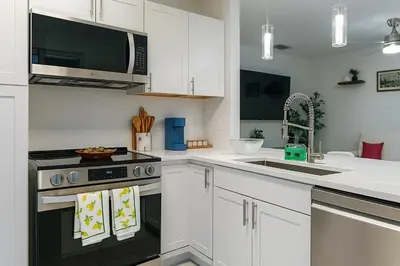 a kitchen with a stove and a microwave at Waterfront HotTub Steps from the Airport Boat Slip in Dania Beach
