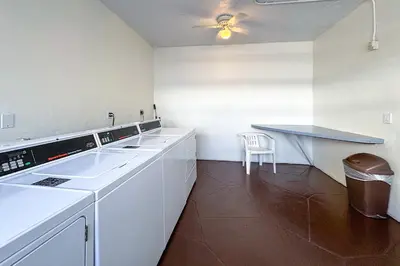 a white kitchen with a counter and a table at Cozy place near Beachside in Sunny Isles Beach