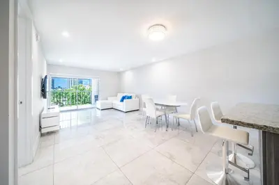 a white living room with a table and chairs at Cozy place near Beachside in Sunny Isles Beach